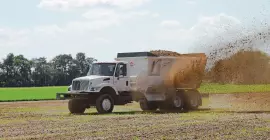 SLC 132 truck mount manure spreader spreading waste in the field. 