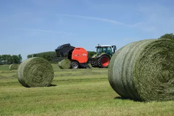 VB 3165 in the field ejecting a completed bale, with a net wrapped bale in the foreground