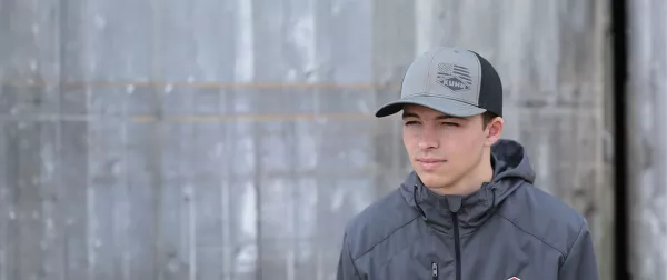 Young man wearing a grey KUHN hat