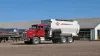 BTC 190 truck-mounted delivery box parked in gravel driveway of large dairy farm.